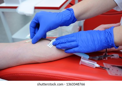 Nurse's Hands Taking Blood From The Vain Of A Donor - Hypodermic Needle, Tubes, Container With Blood