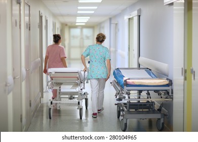 Nurses pushing a mobile bed in a hospital corridor
