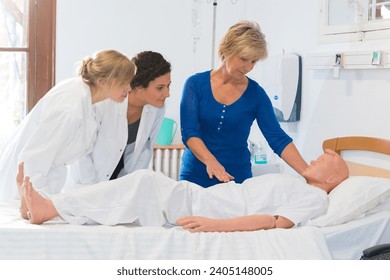nurses training with dummy on bed