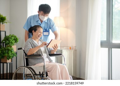 Nursing Home Worker Helping Senior Patient With Application On Tablet Computer