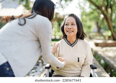 Nursing home, Young caregiver helping senior woman in wheelchair, Volunteer. - Powered by Shutterstock