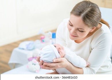 Nursing mother holding her little child 