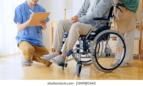 Nursing staff talking to an elderly person sitting in a wheelchair. - Powered by Shutterstock