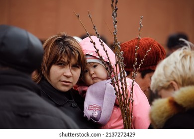 Nur-Sultan, Kazakhstan - April 2019. A Woman With A Child In Her Arms And Willow Branches On A City Street On Palm Sunday. A Willow Branch Is A Traditional Orthodox Symbol Of Easter.