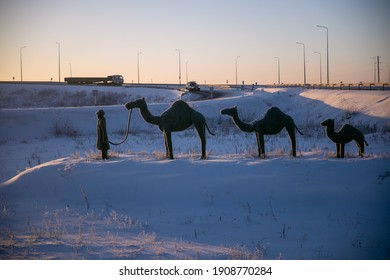 Nur-Sultan, Kazakhstan - January 30, 2021: Sculpture Of Nomadic Herder And Three сamels Near The Highway Interchange. Nur-Sultan, Kazakhstan.