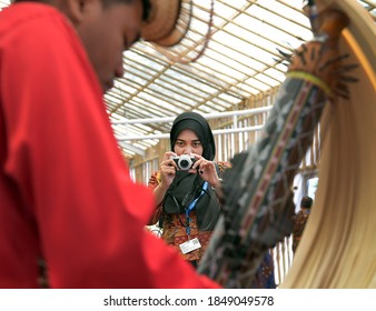 Nusa Dua Bali Indonesia 10/13/2018 A visitor takes pictures of an artist playing traditional musical instruments in a cultural festival