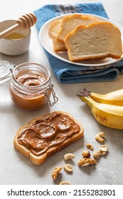 Nut Butter Toast With Bananas And Honey On Light Table. Walnut, Hazelnut And Cashew Nut Spread In Glass Jar. Homemade Breakfast Sandwich. Healthy Food Concept.