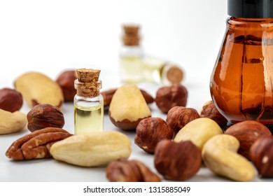 Nut Oil Bottles And Variety Of Nuts On White