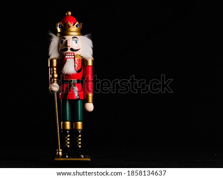 NUTCRACKER DOLL ON BLACK BACKGROUND AND COPY SPACE ON THE RIGHT