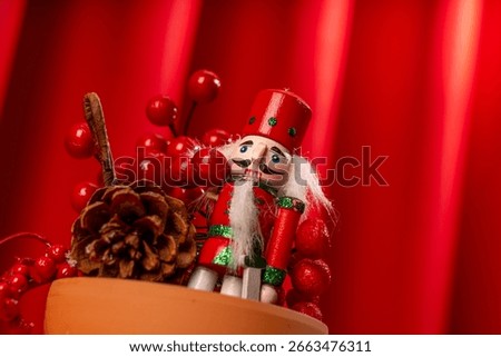 The Nutcracker figure with red curtain background and christmas ornaments 