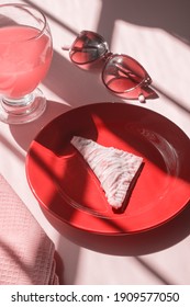 A Nutella Hand Pie On A Red Plate . A Glass And Sunglasses On A Pink Table.