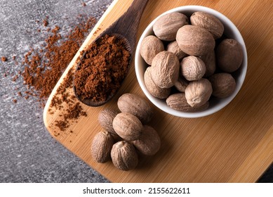 Nutmeg macro in a bowl. Nutmeg powder. Nutmeg spice in a wooden spoon.