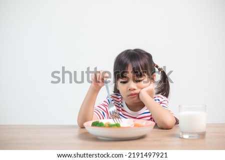 Nutrition healthy eating habits for kids concept. Children do not like to eat vegetables. Little cute girl refuses to eat healthy vegetables.