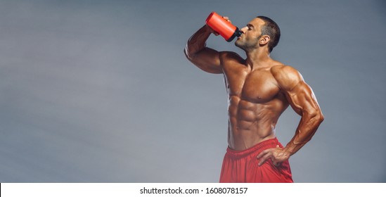 Nutritional Supplement. Muscular Men Drinks Protein, Energy Drink After Workout