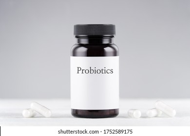 nutritional supplement probiotics bottle and capsules on gray
