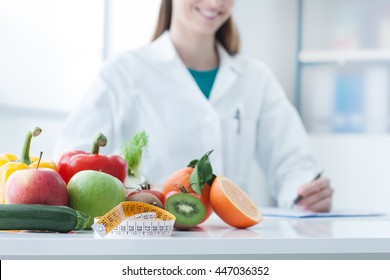 Nutritionist desk with healthy fruit, vegetables and a measuring tape, weight loss and diet concept - Shutterstock ID 447036352