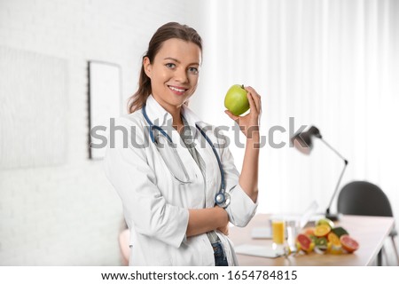 Nutritionist with fresh apple in her office