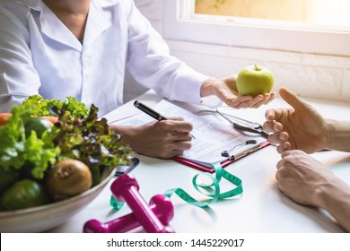 Nutritionist giving consultation to patient with healthy fruit and vegetable, Right nutrition and diet concept - Shutterstock ID 1445229017