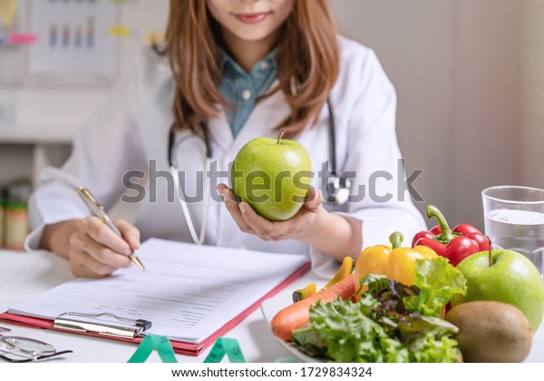 Nutritionist giving\
consultation to patient with healthy fruit and vegetable, Right\
nutrition and diet\
concept