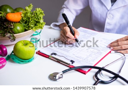 Nutritionist with healthy fruit, vegetable and measuring tape working, Right nutrition and diet concept