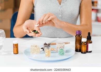 Nutritionist is holding different dietary supplement pills in her hands and writing prescription for daily tablets intake for client for health care - Shutterstock ID 2260100463