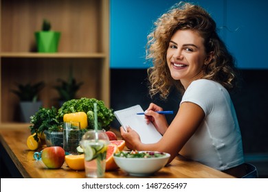 Nutritionist working in office. Doctor writing diet plan on table and using vegetables. Sport trainer. Lifestyle.
