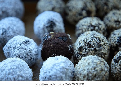 Nutritious vegan sweets made from dates, nuts, raisins and cocoa close together
