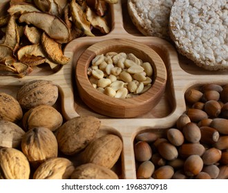 nuts, dried apples, bread on a wooden plate. close-up