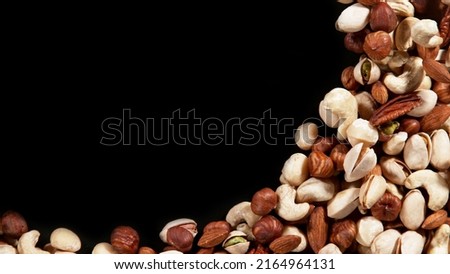 Nuts mix islated on black background, top view with copyspace. Assorted mixed nuts isolated on dark table.