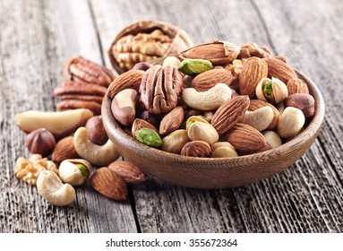 Nuts mix in a wooden plate - Shutterstock ID 355672364
