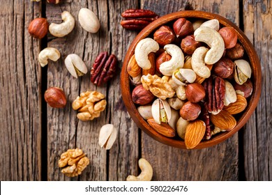 Nuts Mixed in a wooden plate.Assortment, Walnuts,Pecan,Almonds,Hazelnuts,Cashews,Pistachios.Concept of Healthy Eating.Vegetarian.selective focus. - Shutterstock ID 580226476
