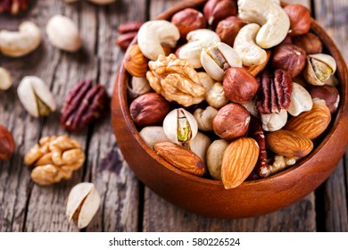 Nuts Mixed in a wooden plate.Assortment, Walnuts,Pecan,Almonds,Hazelnuts,Cashews,Pistachios.Concept of Healthy Eating.Vegetarian.selective focus. - Shutterstock ID 580226524