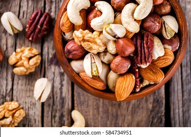Nuts Mixed in a wooden plate.Assortment, Walnuts,Pecan,Almonds,Hazelnuts,Cashews,Pistachios.Concept of Healthy Eating.Vegetarian.selective focus. - Shutterstock ID 584734951