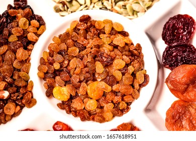 Nuts And Raisins In Wooden Bowl. Snack Mix Of Dried Almonds, Hazelnuts, Cashews And Raisins. Trail Mix. Edible, Raw, Organic And Vegan. Isolated Macro Food Photo Closeup From Above On White Background