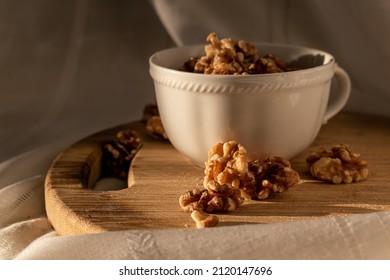 Nuts In White Tea Cup On Wooden Chopper