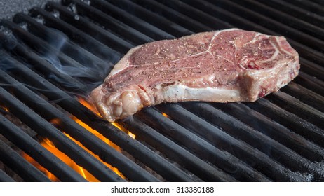 NY Strip Steak Cooking On Grill With Flames And Smoke