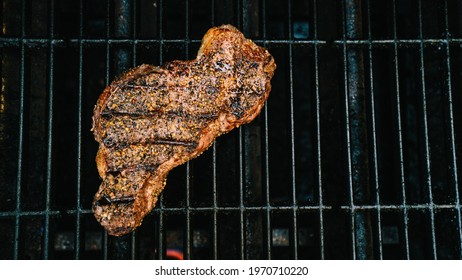 NY Strip Steak Grilling On Barbeque Grill Overhead View. Beef High Quality Photo