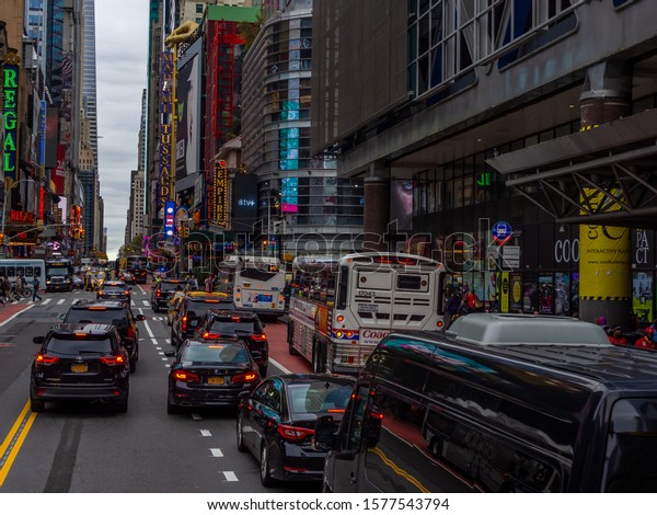 NYC, New York / USA - November 2019: Bussy road at\
Times Square Broadway. Cars under tall skyscrapers and commercial\
ads.