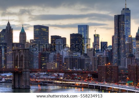 NYC skyline at sunset with the night lights of the downtown skyscrapers and the Brooklyn Bridge in Manhattan, New York City