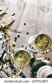 NYE Background: Focus On Glasses Of Champagne Amidst Confetti And Favors