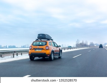 Nyiregyhaza, Hungary – January 06, 2017: Orange Car With Roof Luggage Box On Highway In Winter