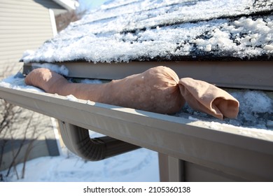 Nylon Salt Sock Made From Old Pantyhose And Rock Salt To Melt An Ice Dam Over A Gutter Downspout