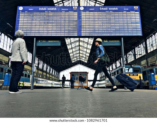 Nyugati Railway station in\
Budapest, people standing in front of the timetable,\
2018/04/26