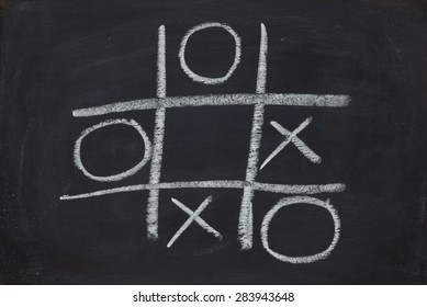 O X Game On Black Chalk Board