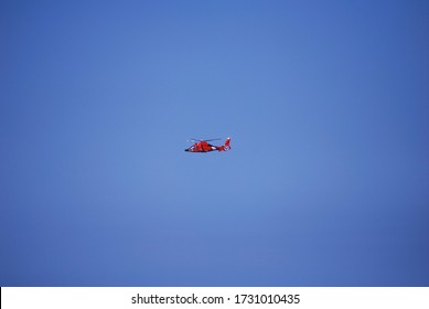 Oahu, Hawaii, USA - December 6 2008: An Orange US Coast Guard Rescue Helicopter Against  A Bright Blue Cloudless Sky. Daytime, North Shore, Oahu.