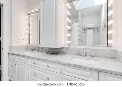 OAK PARK, IL, USA - JUNE 2, 2020: A Classic, Hollywood Style Mirror Surrounded By Light Bulbs In A White Bathroom.