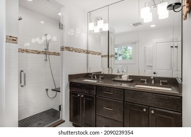 OAK PARK, IL, USA - MAY 5, 2021: A Beautiful Bathroom With A Dark Wooden Vanity Cabinet And A Tiled Walk-in Shower.