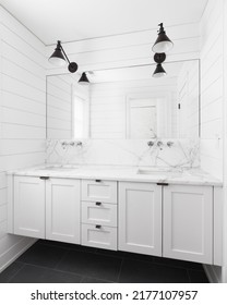 OAK PARK, IL, USA - MAY 24, 2022: A Farmhouse Style Bathroom With Shiplap Walls, A White Floating Vanity Cabinet, And Lights Mounted Above The Mirror.