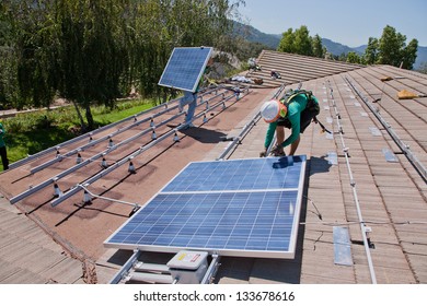 OAK VIEW - OCTOBER 10: Workers Install Solar Panels On The Roof Of A House On October 10, 2011 In Oak View, Southern California