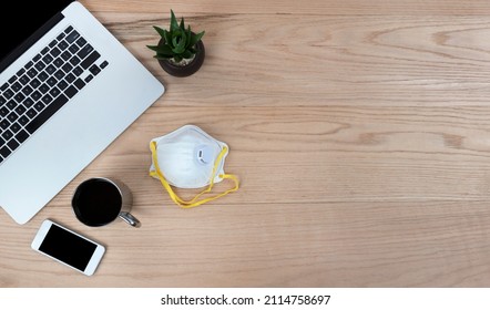 Oak Wood Office Desk Table With Laptop Computer, Personal Face Mask, Smartphone, Baby Plant And Coffee Drink For Going Back To Work Or School During The Covid Pandemic. 